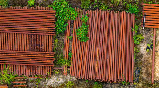 Aerial view of rusty industrial pipes stacked in rows at the Garzweiler surface mine in Juchen, North Rhine-Westphalia, Germany.