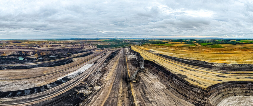 Aerial view of the Garzweiler surface mine showing massive open-pit coal extraction, industrial machinery, and surrounding agricultural landscape in Juchen, North Rhine-Westphalia, Germany.