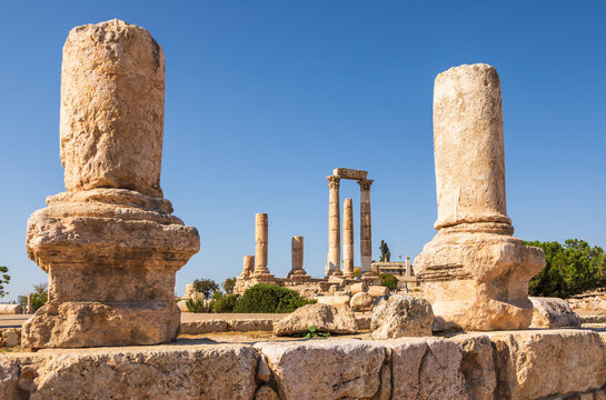 View of the ancient stone columns and ruins of the Amman Citadel under a clear blue sky in Amman, Amman Governorate, Jordan.