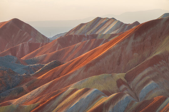 View of the colorful, layered sandstone formations of the Zhangye Danxia National Geopark, showcasing vibrant red, orange, and yellow mineral deposits in Zhangye, Gansu, China.