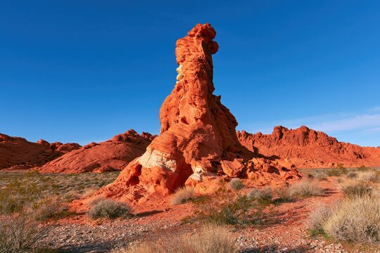 Tall Red Rock Formation in Desert Landscape