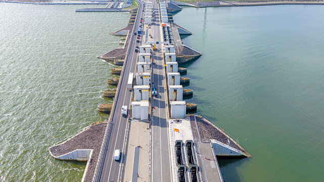 Aerial view of Stevinsluis, a large sluice complex and bridge structure separating the Wadden Sea and IJsselmeer with traffic in Den Oever, Noord-Holland, Netherlands.