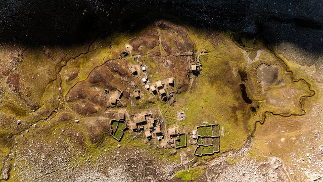 Aerial view of Supat Valley Kohistan, featuring stone dwellings and small green agricultural enclosures nestled within the rugged, rocky landscape of Kohistan, Khyber Pakhtunkhwa, Pakistan.