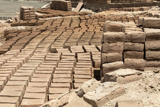 View of rows of sun-dried mud bricks laid out to dry on the ground at a brick-making site near Charasa Gonpa in Charasa, Ladakh, India.
