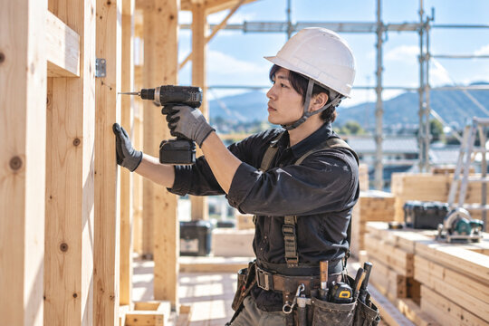 木造現場で電動ドリルを使う作業員