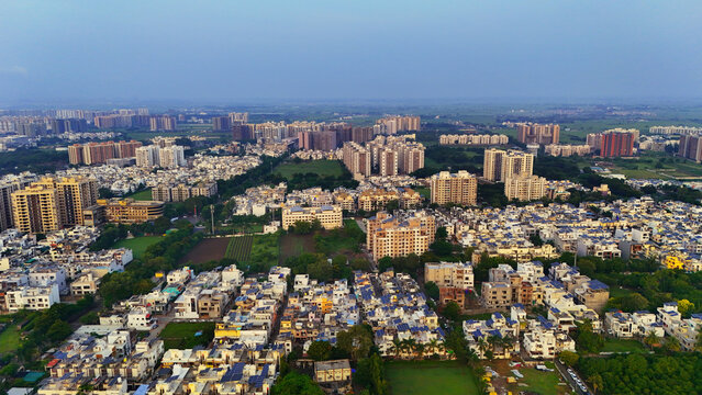 Aerial view of the sprawling urban landscape of Surat featuring dense residential apartment complexes, modern housing developments, and green patches in Surat, Gujarat, India.