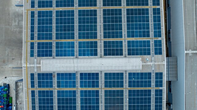 Aerial view of a large warehouse roof featuring extensive solar panel arrays for renewable energy generation in Bhiwandi, Maharashtra, India.