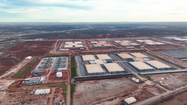 Aerial drone view of a large data center construction site in Abilene, Texas, with cranes, steel framework and heavy equipment on flat West Texas land