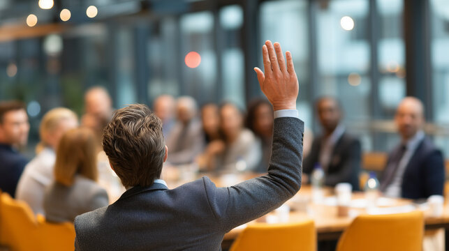 Business professional raising hand to ask question during corporate meeting or conference