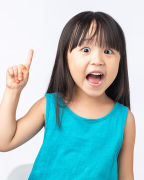 Happy Asian girl pointing finger up having a great idea, eureka moment or discovery concept.