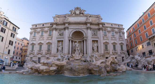 View of the Trevi Fountain with its intricate Baroque sculptures and flowing water, surrounded by historic buildings in Rome, Lazio, Italy.