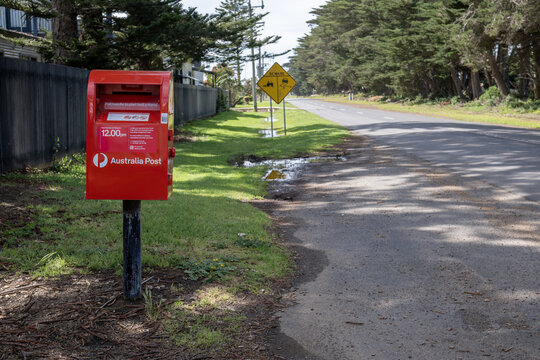 Australia Post post box beside a grass verge on a quiet rural road in Werribee South, Melbourne, Australia. Postal service and rural mail access, public service infrastructure 
