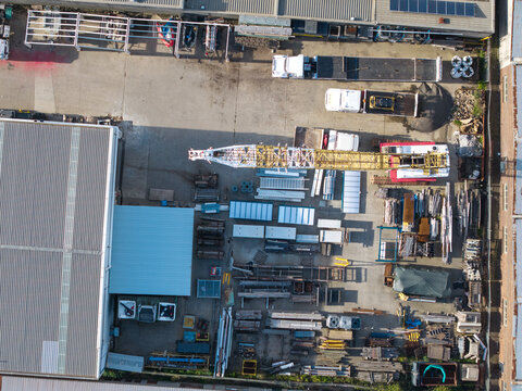 Melbourne, VIC, Australia - 05 October 2026: Aerial view of industrial site in Boronia and Bayswater, Melbourne, with a large crane, construction materials, and factory buildings.