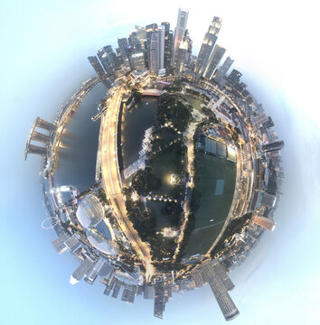 Singapore - 05 November 2019: Aerial view of the Singapore skyline in a 360-degree tiny planet projection, featuring Marina Bay Sands, modern skyscrapers, and urban parklands at dusk.