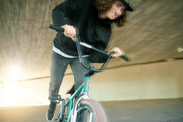 Naklejka premium BMX, motion blur and ride with man on bike for activity, adrenaline hobby or sports training. Exercise, risk and speed with extreme person on bicycle underground for action, cycling or energy
