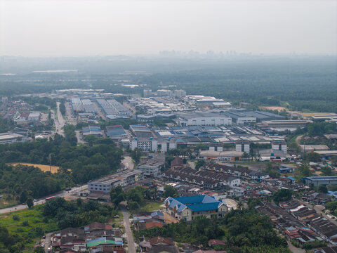 Pekan Nanas, Johor, Malaysia - 04 March 2026: Aerial view of Pekan Nanas featuring industrial warehouses, residential neighborhoods, and surrounding greenery under a hazy sky.