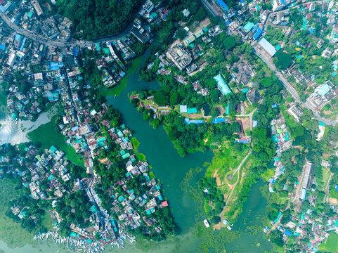 Rangamati, Chittagong Division, Bangladesh - 07 September 2024: Aerial view of Rangamati town along the green banks of Kaptai Lake with dense vegetation and boats.