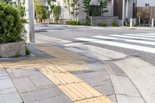 Tactile paving and curb ramp at a quiet street crossing
