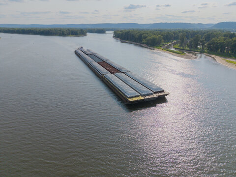 Bagley, Wisconsin, United States - 24 July 2026: Aerial view of a large barge navigating the Mississippi River near Wyalusing Public Beach, surrounded by lush green forests.
