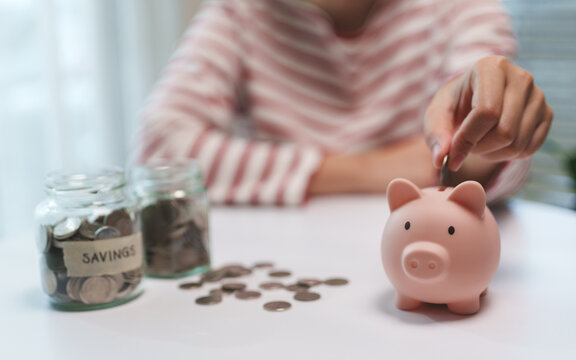 Person putting a coin into piggy bank to grow savings, strengthen financial security, and prepare for future retirement goals.