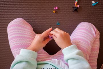 家でレゴのオモチャを遊んでいる幼児の女の子の指の様子 © zheng qiang