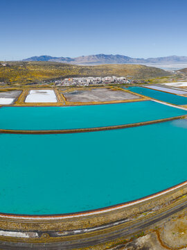 Ogden, Utah, United States - 30 September 2026: Aerial view of the Western Zirconium Inc factory and its turquoise wastewater evaporation ponds near arid hills.