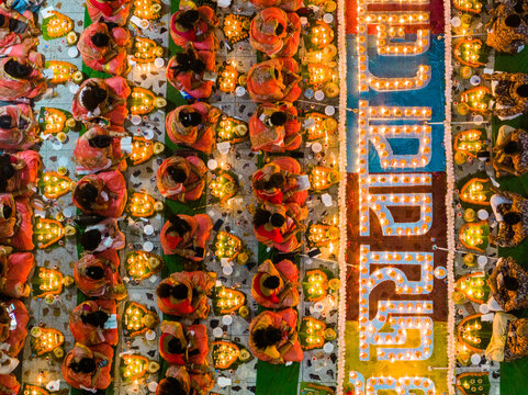 Dhaka, Bangladesh - 11 November 2023: Aerial view of people gathered at Swamibagh Temple, surrounded by rows of glowing oil lamps arranged in intricate patterns during a religious festival.
