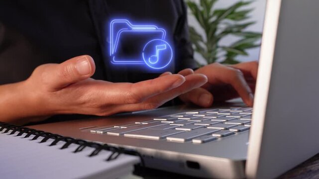 Music files. Close-up of the hands of a businesswoman working on her laptop while holding a virtual folder icon featuring a musical note.