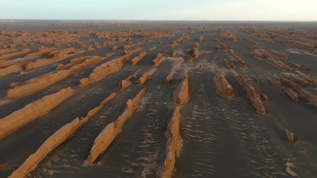 Aerial view of Yadan National Geological Park with wind-eroded rock formations and desert sand dunes in Jiu Quan Shi, Gan Su Sheng, China.