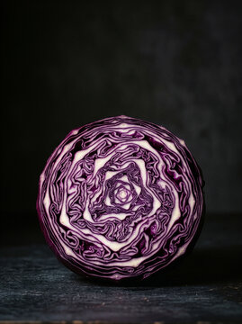 Red cabbage cut in half on dark moody background