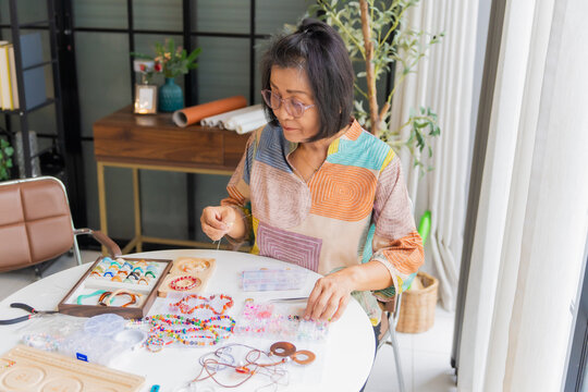 Asian woman making handcrafted jewelry