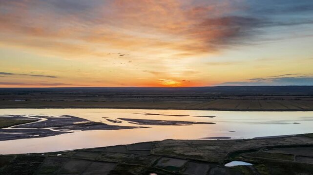 Aerial time-lapse of Yellow River at sunrise over Hetao plain with sandbars and farmland in autumn, Inner Mongolia, China.