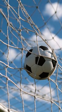 Soccer ball stuck in white goal net against
