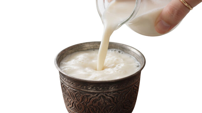 Traditional ayran yogurt drink pouring into ornate metal cup, fresh buttermilk beverage stream isolated on white, authentic oriental lassi pour