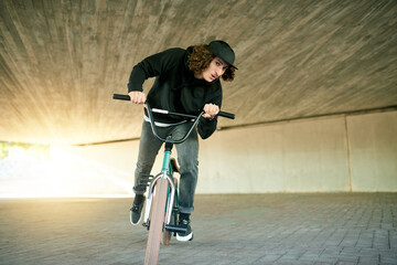 Naklejka premium BMX, ride and underground with man on bike for activity, adrenaline hobby or extreme sports training. Exercise, risk and speed with person on bicycle in urban park for action, cycling or energy