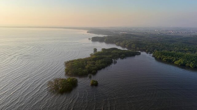 Golden dawn glows over tranquil water. Ripples dance across the surface gently at Probolinggo