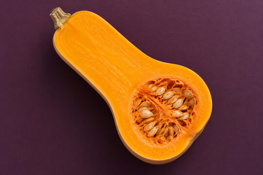 Lengthwise butternut squash half with orange flesh and a natural seed cavity