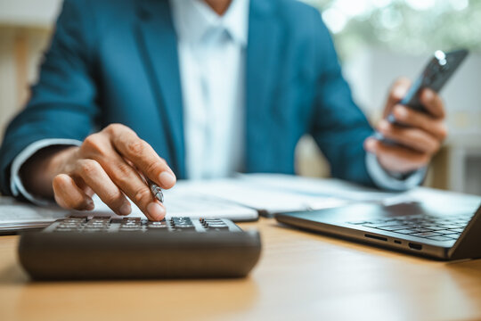 Papers and a digital workspace support corporate finance calculation. Corporate, finance, and capital connect with roi and investment; corporate is suggested by the props. The view is clear.