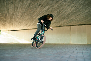 Naklejka premium BMX, exercise and ride with man on bike for activity, adrenaline hobby or extreme sports training. Fitness, risk and speed with person on bicycle underground for action, energy or urban cycling