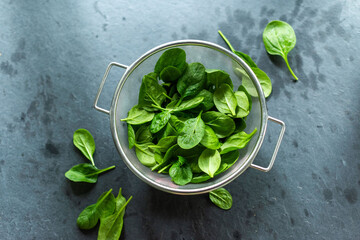 Fototapeta premium Fresh spinach leaves in colander