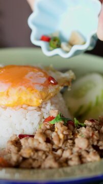 Pouring Chili Fish Sauce over Pad Krapow Minced Pork and Fried Egg