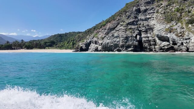 Turquoise water washing against cliff rocks in a Caribbean cove