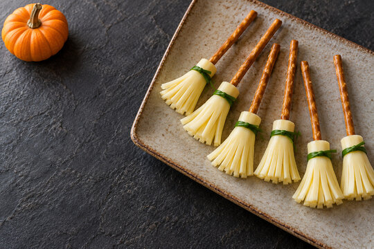Halloween cheese broom snacks with pretzel handles