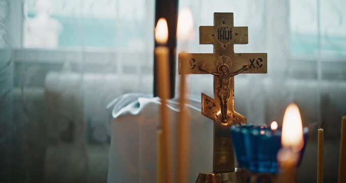 Orthodox Crucifix and Burning Prayer Candles Inside a Church