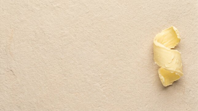 Artisan French butter curl ribbon on pale sandstone with copy space