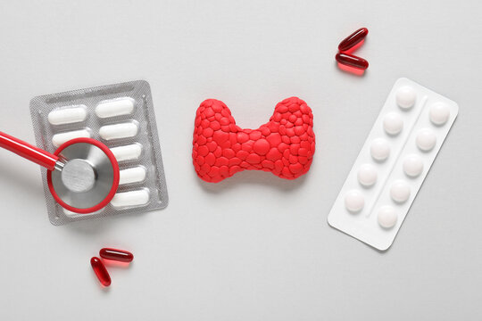 Thyroid health and endocrine disease, medical treatment with pills and stethoscope for hormone imbalance and hyperthyroidism diagnosis on gray background