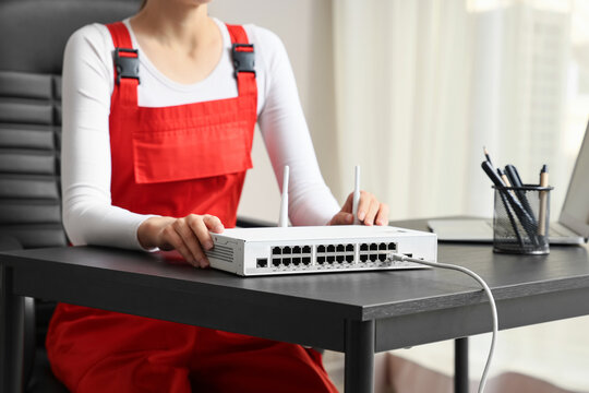 Network infrastructure and IT support, technician installing internet router and ethernet switch for business connectivity in office