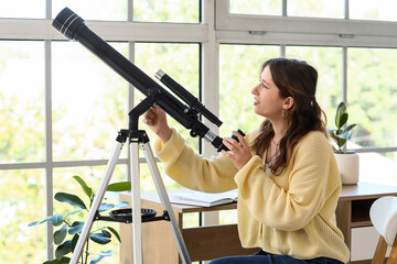 Fototapeta premium Astronomy and scientific discovery, young woman using a telescope to explore space and science education in a bright home office with natural light