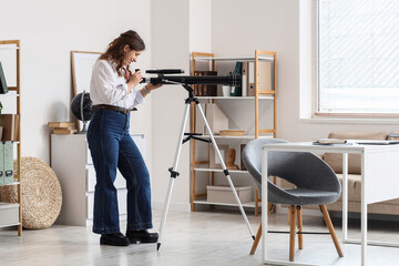 Fototapeta premium Scientific discovery and curiosity, young woman looking through a telescope in a home office for astronomy research and education
