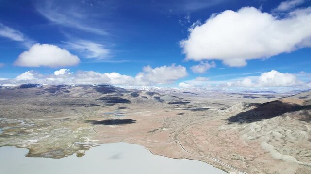 Drone view landscape of Ali in Xizang, snow mountains and lakes with blue sky and white clouds background in sunny day in Tibet, China, 4k real time footage b roll travel concept